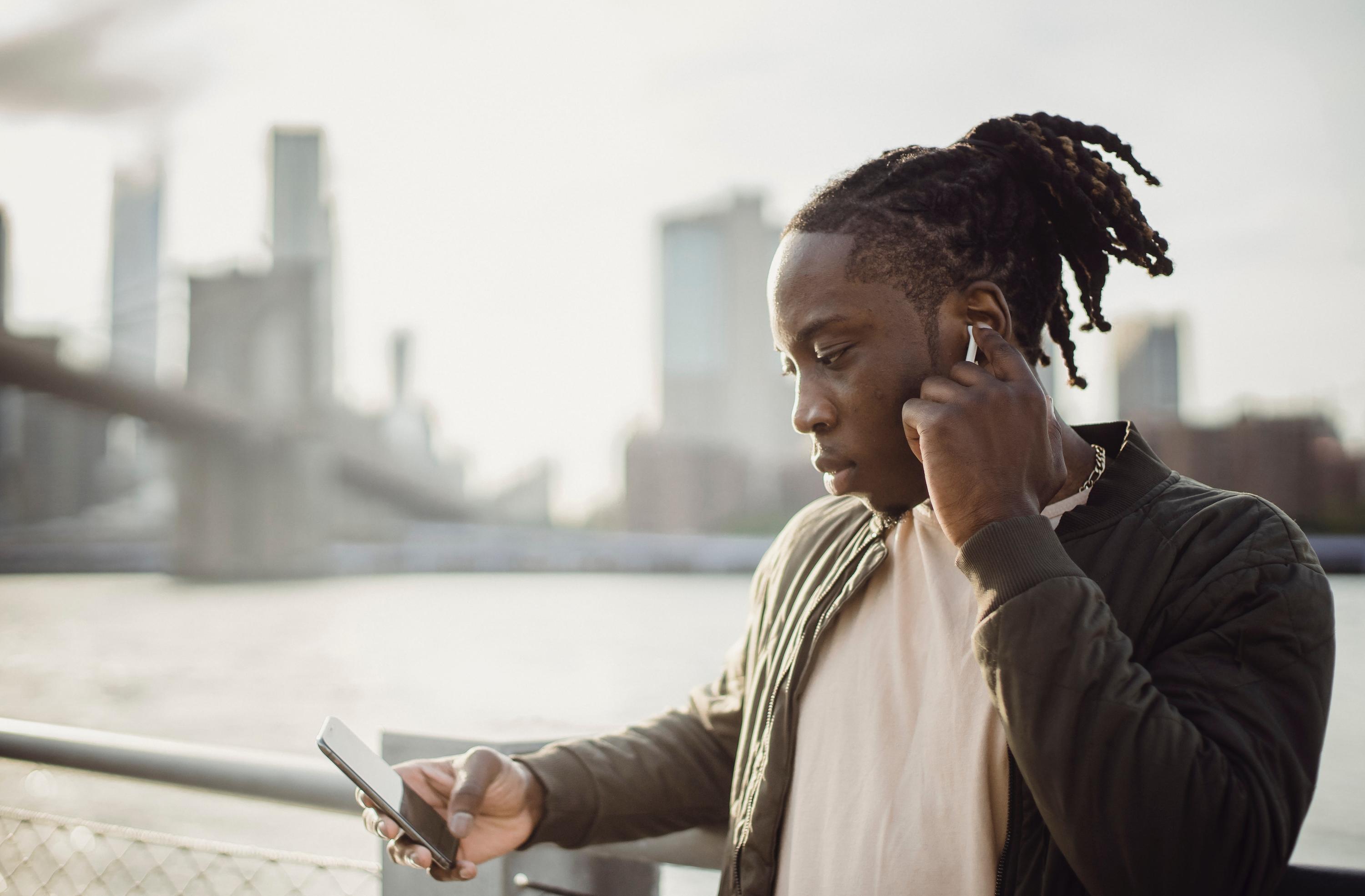 Man standing on a bridge looking at his phone