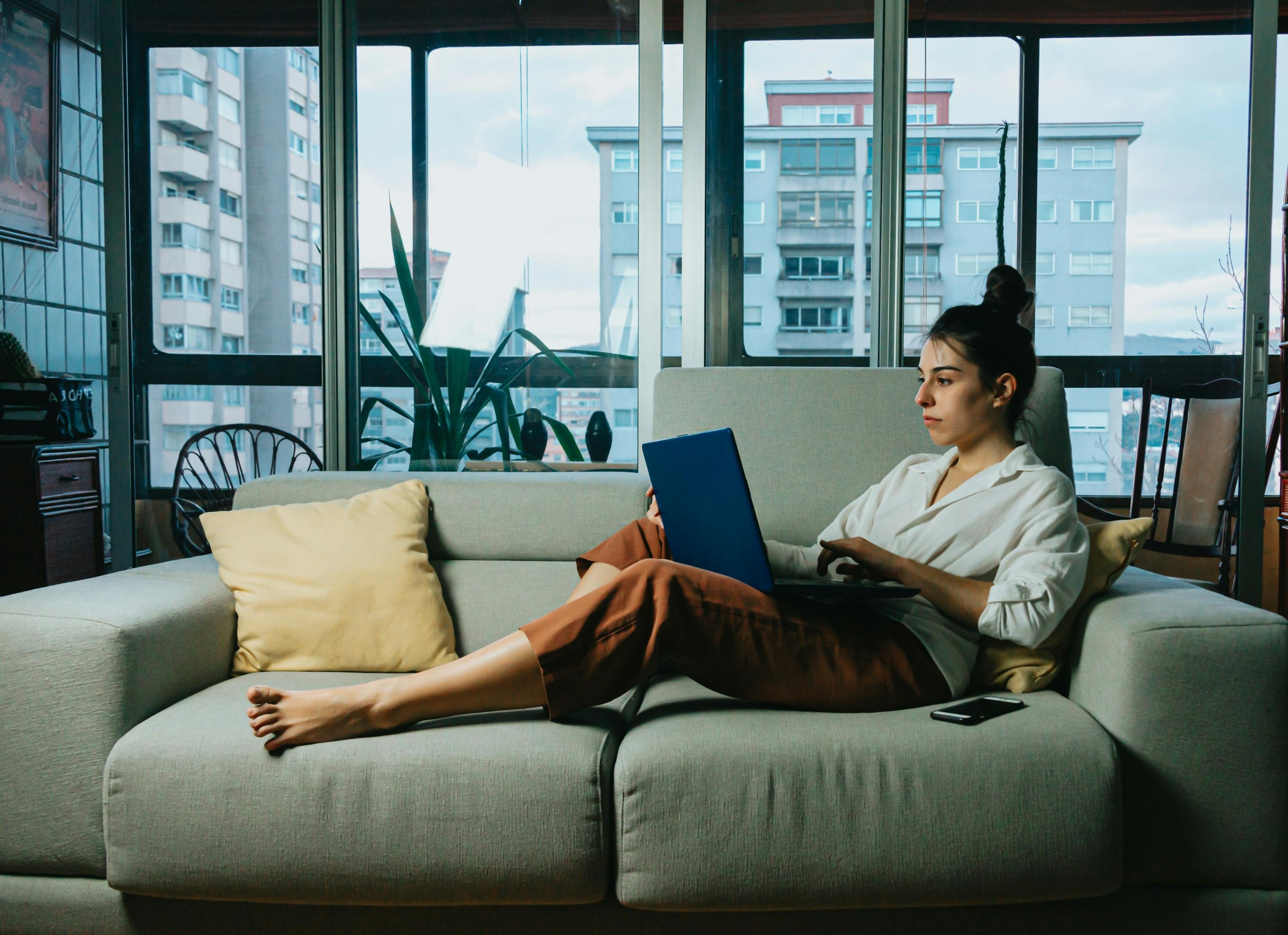 Woman on couch with laptop.