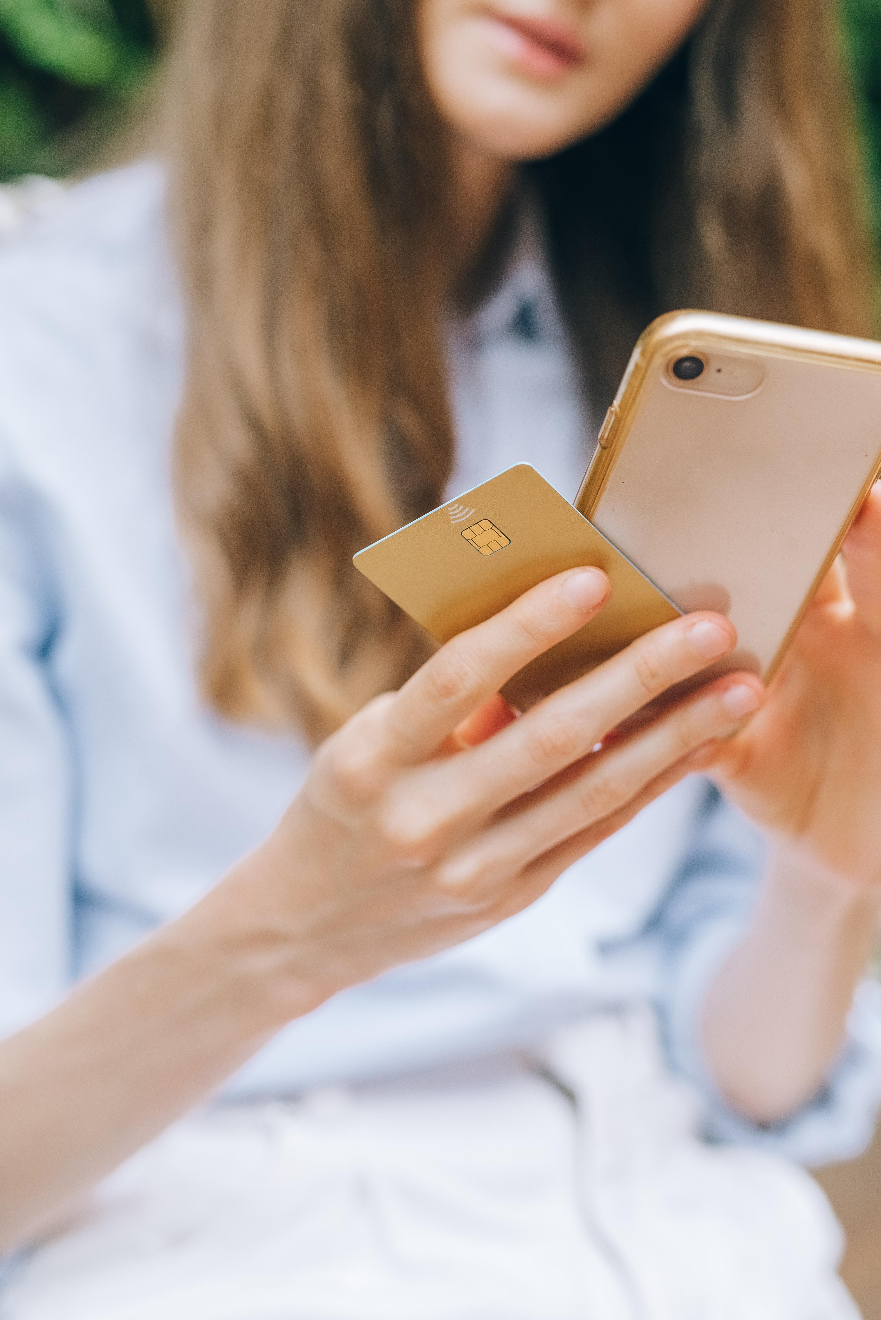 Woman holding her smartphone and credit card