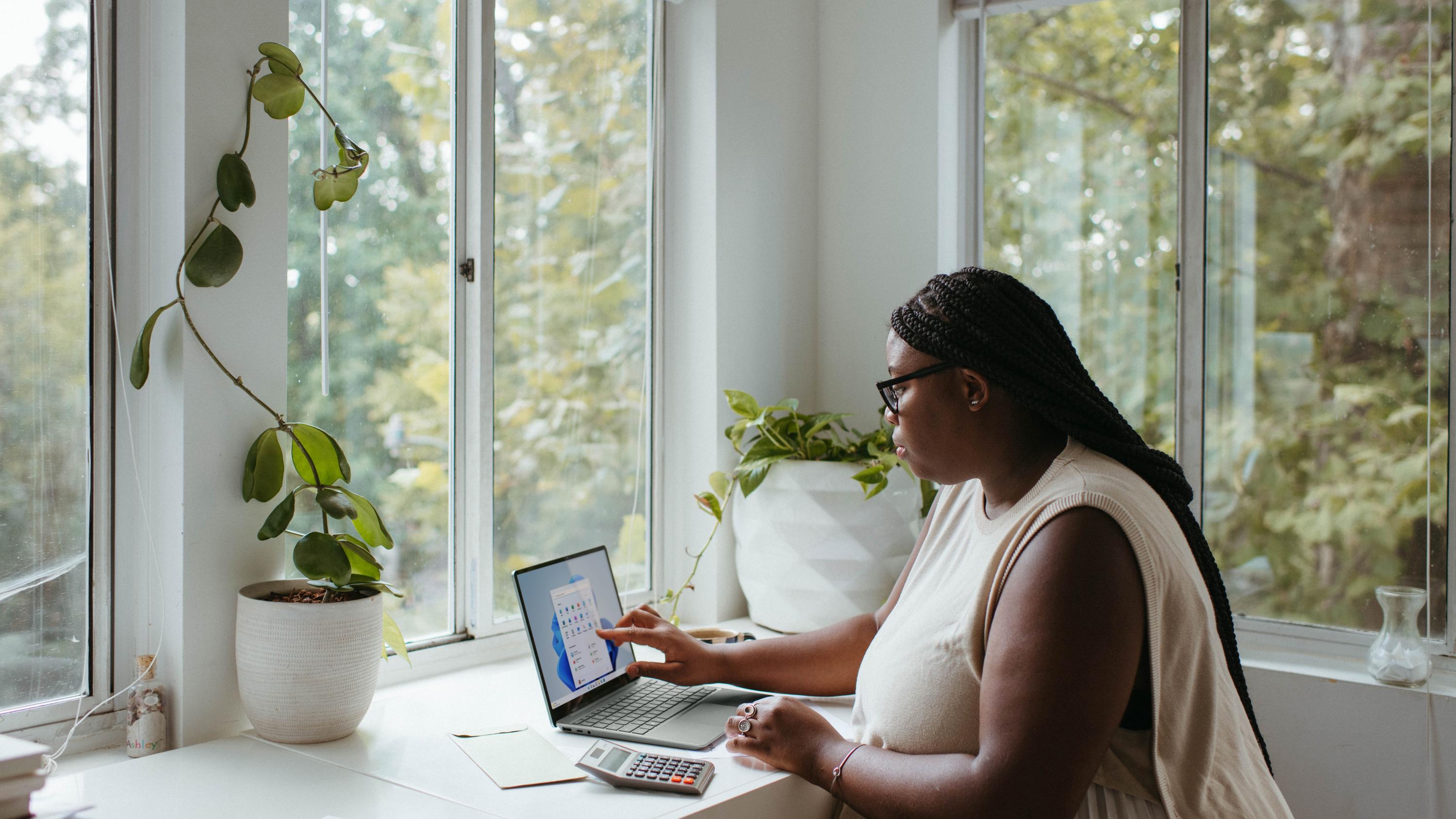 Woman using her touchscreen laptop at a desk