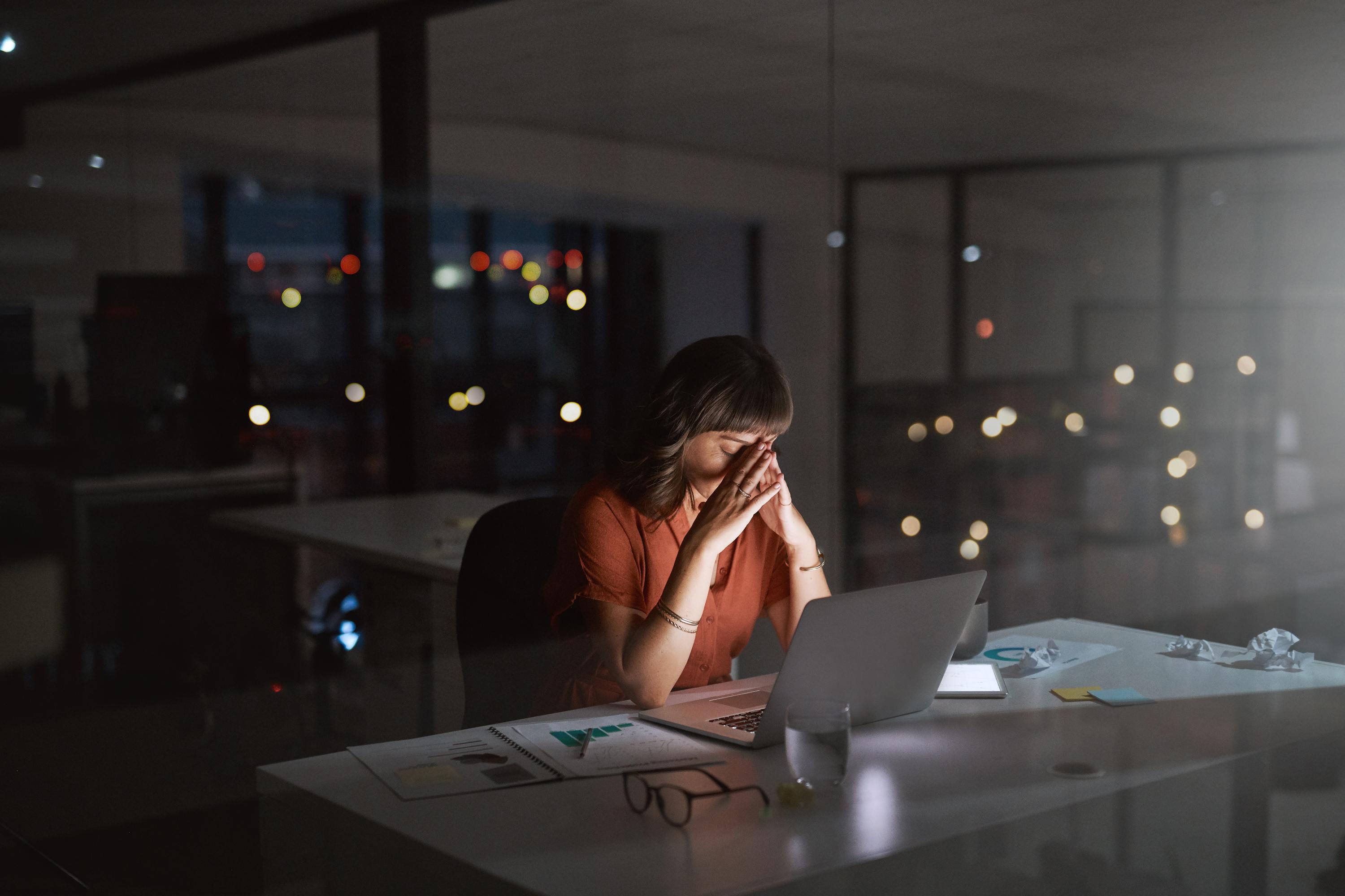 Women in office at desk late night. 