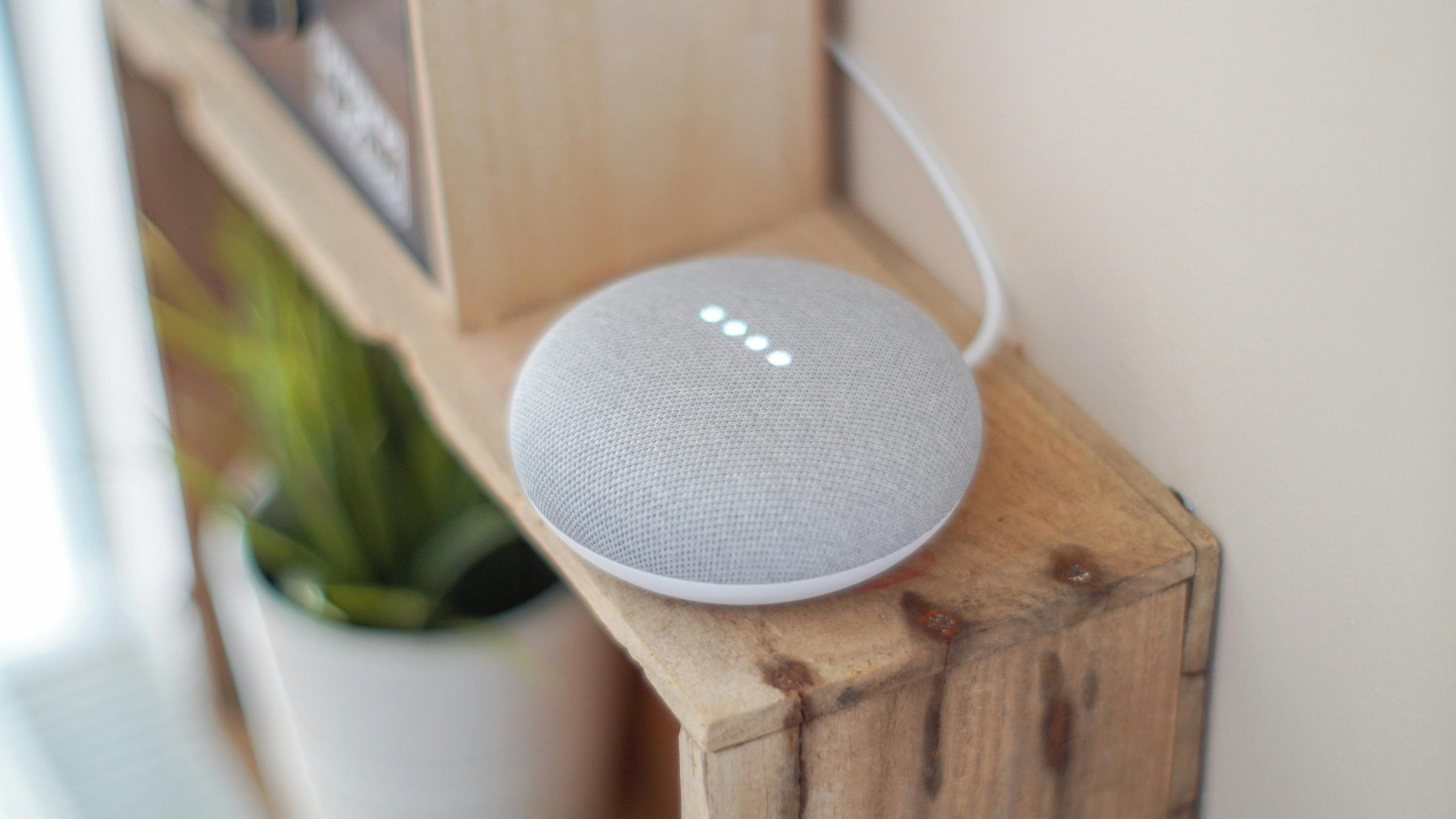 A Google dot speaker on a wooden piece of furniture