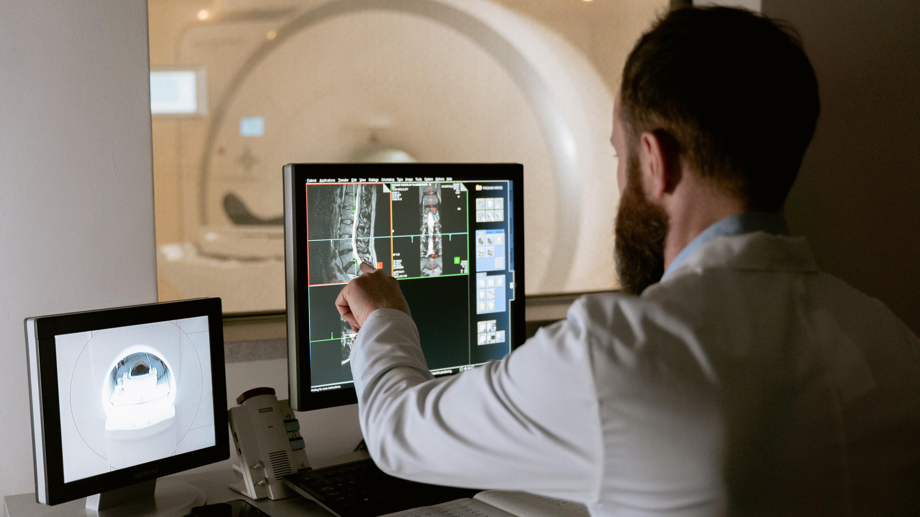 Man pointing at an x-ray image on a monitor