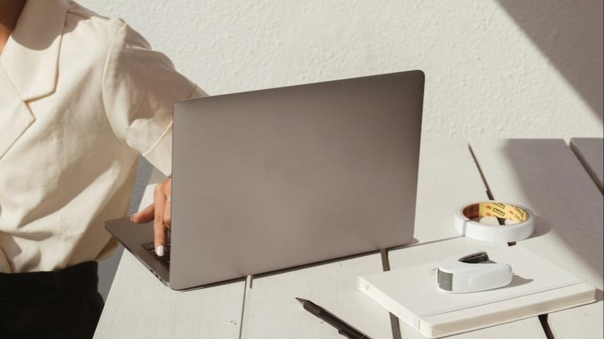 Woman sitting at a table with her laptop and other office supplies